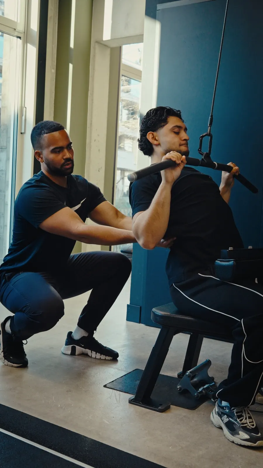 Hands-on coaching during a lat pulldown session
